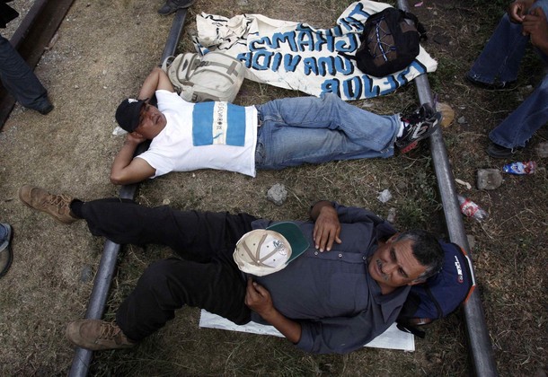 Migrants lie on the train tracks during a protest to raise awareness of violence towards migrants in Chahuites