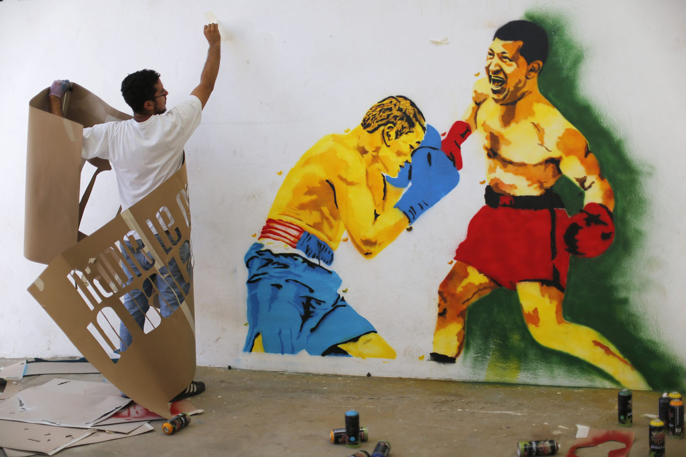 A member of the 'communication army' works on graffiti depicting Venezuela's President Chavez in the suburbs of Caracas
